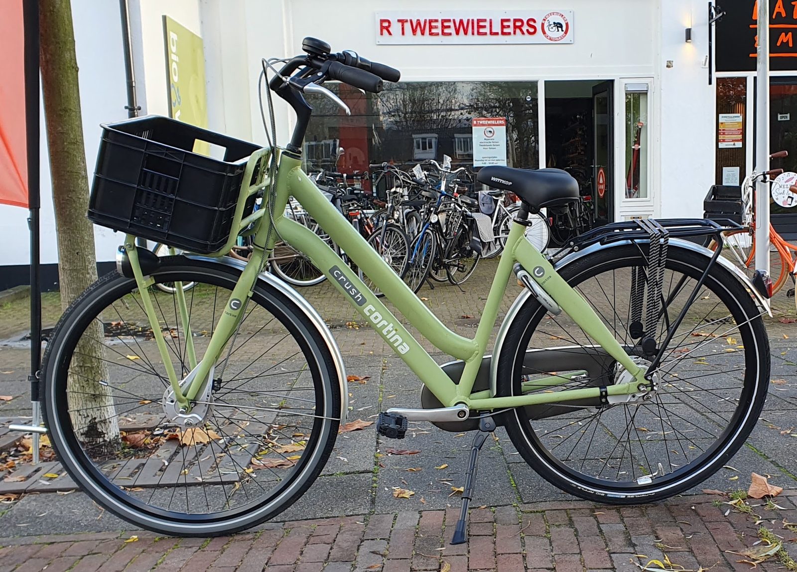 Groene Cortina-fiets met kratje voor de winkel van R Tweewielers in Zoetermeer